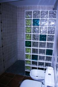 a bathroom with a toilet and a wall of water bottles at Casa Tenerías in Marchagaz