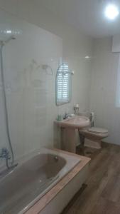 a bathroom with a tub and a sink and a toilet at Casa Ania in Villanueva de Arosa