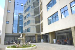 un grande edificio con una fontana di fronte di La Maison Royale a Nairobi