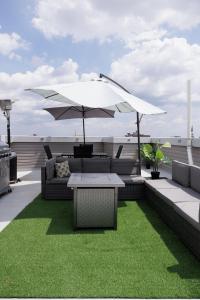 a patio with a table and an umbrella and grass at Montgomery condo in Philadelphia