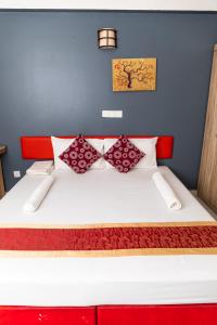 uma cama com almofadas vermelhas e brancas em The G Ten Holiday Inn em Hulhumale