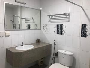 uma casa de banho com um lavatório, um WC e um espelho. em The G Ten Holiday Inn em Hulhumale