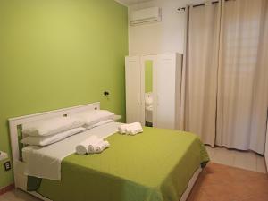 a green bedroom with a bed with towels on it at Bed & Breakfast Ilary in Marsala