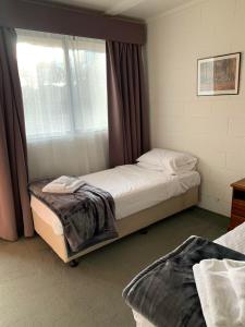 a bedroom with two beds and a window at Robertson Country Motel in Robertson
