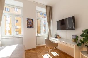 a bedroom with a desk and a tv on a wall at Vienna Central Apartment in Vienna