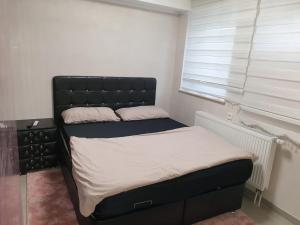 łóżko z czarnym zagłówkiem w sypialni w obiekcie Sehr grosse 5 Zimmer Wohnung mit Garten und terasse w mieście Wiesbaden