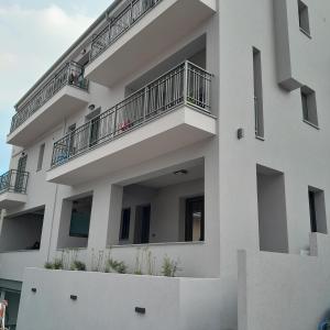 a white building with balconies and plants on it at Brand new flat near de bosset bridge, Argostoli in Argostoli