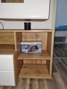 una caja en una estantería de madera bajo una TV en Maria Apartment en Wolfsburg