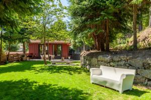 a white couch sitting in a yard next to a stone wall at Villas Prendal Eco Living - Minho's Guest in Guimarães
