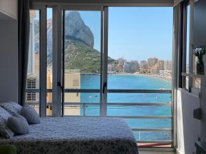 a bedroom with a view of a body of water at Estudios HORIZONTE BEACH in Calpe
