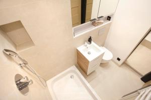 a bathroom with a sink and a toilet and a mirror at Apartament Ada in Sopot