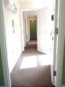 un couloir avec des portes blanches et un mur vert dans l'établissement Spacious Entire Flat,1D, à Great Yarmouth