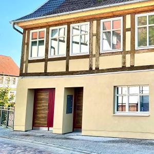 uma casa com portas vermelhas numa rua em stilvolle, zentrale Ferienwohnung Bocksbruecke mit Parkplatz em Salzwedel