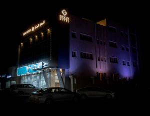 un edificio con coches aparcados delante de él por la noche en Shyan Hotel en Medina