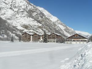 a lodge in the snow with a snow covered mountain at Appartements Monte Rosa in Täsch