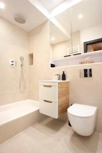 a bathroom with a toilet and a tub and a sink at Apartament Ada in Sopot