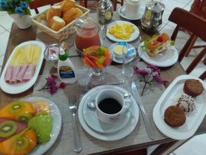 a table topped with plates of food and a cup of coffee at Pousada Arrastão da Ilha in Abraão