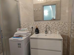 a bathroom with a sink and a washing machine at Blue in Gaeta
