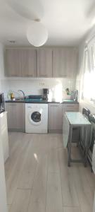 a kitchen with a washing machine and a table at Nid de verdure à 15 minutes centre et plage in Le Havre