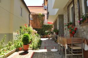 eine Außenterrasse mit einem Tisch, Stühlen und Pflanzen in der Unterkunft Chanovi apartments in Ohrid