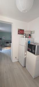 a kitchen with white appliances and a white floor at Nid de verdure à 15 minutes centre et plage in Le Havre
