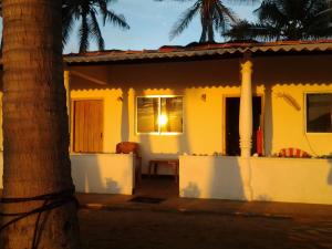 a yellow house with a window and a palm tree at Dolphinchilling in Alankuda