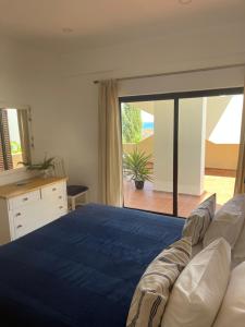 ein Schlafzimmer mit einem blauen Bett und einer Glasschiebetür in der Unterkunft Lagos Sea View Apartment in Lagos