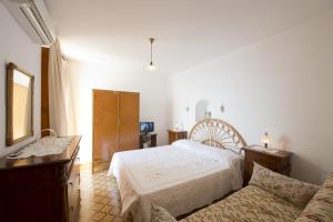 een slaapkamer met een wit bed en een bank bij Gabbiano in Praiano