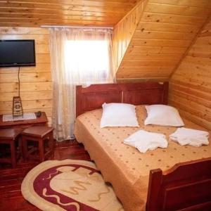 a bedroom with a bed in a wooden room at Cabana Ancuța in Vartop