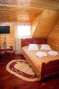 a bedroom with a large bed in a wooden room at Cabana Ancuța in Vartop