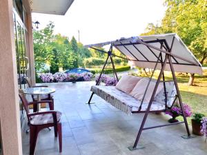 a porch with a bed and a table at Guest House Dimitrije in Niška Banja