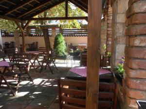 eine Terrasse mit Tischen und Stühlen und einer Ziegelwand in der Unterkunft Villa Iva in Skopje