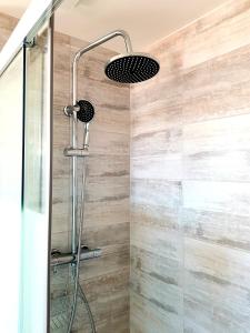 a shower with a shower head and a glass door at Appartement dans le bourg du Guildo - Saint-Cast in Saint-Cast-le-Guildo
