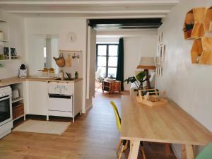 a kitchen with a table and a dining room at A l'Ombre de la Dame in Cucuron