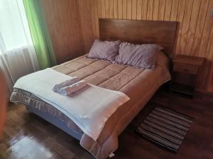 1 cama con 2 toallas en un dormitorio en Cabañas Altos de la Chacra en Castro, 3 dormitorios, en Castro