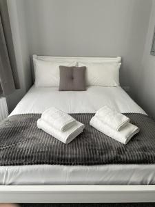 un letto bianco con due cuscini sopra di Ravna Gora a Londra