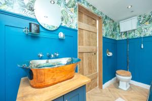 a bathroom with a wooden sink and blue walls at Brandy cove in Swansea