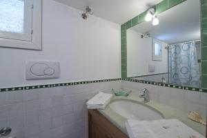 uma casa de banho com uma banheira, um lavatório e um espelho. em Gabbiano em Praiano