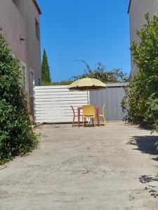 stół i krzesła pod parasolem na patio w obiekcie Appartement avec extérieur et parking gratuit w Perpignanie