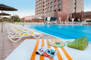 una piscina con sedie e un'auto giocattolo su un tavolo di Leonardo Hotel Negev a Beer Sheva