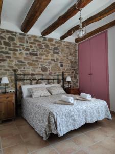 ein Schlafzimmer mit einem Bett und einer Ziegelwand in der Unterkunft Casa Escola in Pobla de Segur