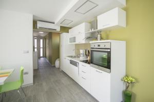 una cocina con armarios blancos y fregadero en Villa Danex Premium, en Umag