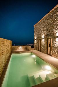 a swimming pool in the backyard of a house at night at Mani Luxury Suites and Studios in Gytheio with Private Pools in Gythio