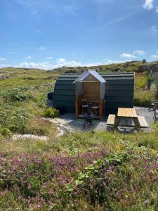a yurt with a table and a bench in a field at Earls View Pod in Carna