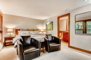 a bedroom with a bed and a table and two chairs at Luxury Ski In, Ski Out 3 Bedroom Mountain Residence In The Heart Of Lionshead Village With Heated Slope Side Pool And Hot Tub in Vail