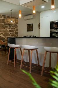 eine Küche mit einer Bar mit Hockern und einer Theke in der Unterkunft Casa de Campo Gracinda in Tourém