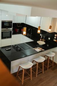 a kitchen with a black counter and white cabinets at Casa de Campo Gracinda in Tourém