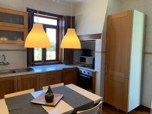 una cocina con dos luces colgando sobre una mesa en Bam’s Farm, en Alcobaça