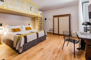 a bedroom with a large bed and a desk and a desk at Hotel Priori Secret Garden in Perugia