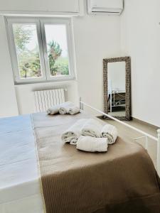 een slaapkamer met 2 handdoeken op een bed met een spiegel bij Villa Bella Luna with Pool - Puglia Mia Apartments in Monopoli